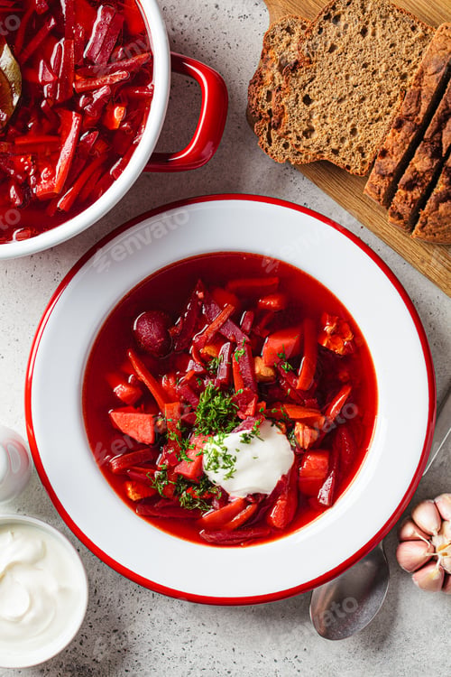 Preview: Beetroot soup borsch with garlic, sour cream and dill in plate, flat lay.