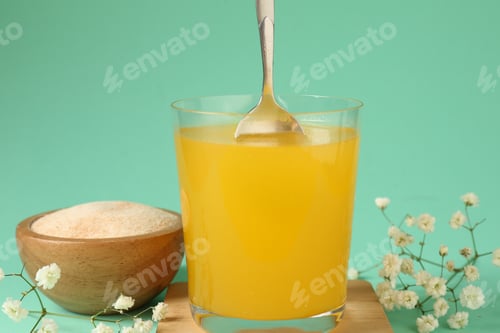 Preview: Stirring collagen powder in water on turquoise background, closeup