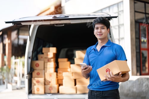 Preview: Smiling delivery asian man standing in front of his van. Portrait of courier delivering parcel
