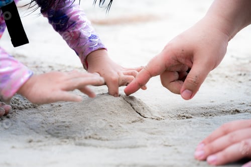 Preview: Close Up little girl's hand was drilling hole in small pile of sand she had made.