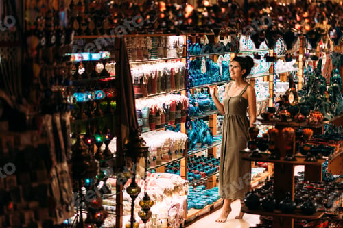Preview: Beautiful girl in a souvenir shop in Turkey. Girl chooses a souvenir Oriental shop. Street shop