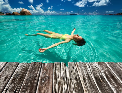 Preview: Woman In Bikini Lying On Water At Tropical Beach