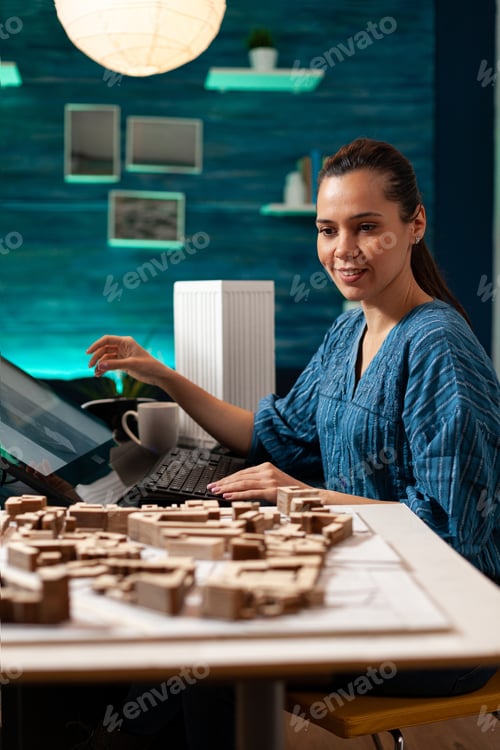 Preview: Young architect working on building miniature maquette