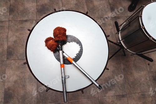 Preview: percussion mallets resting on a drum head in an interior