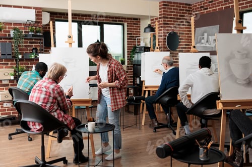 Preview: Young teacher helping senior woman to develop illustration technique