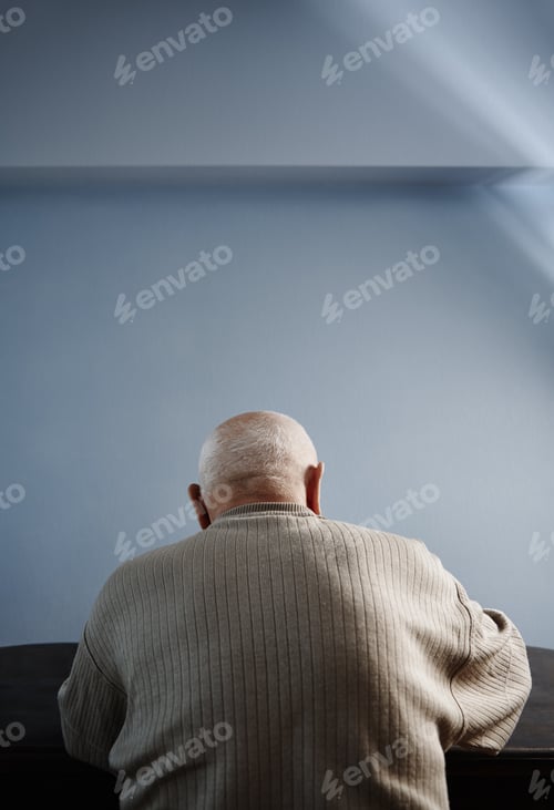 Preview: Back view on senior man sitting at the table