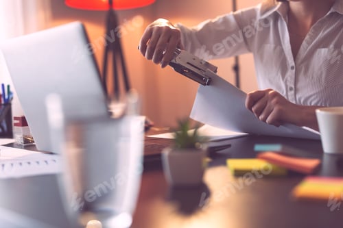 Preview: Businesswoman using stapler