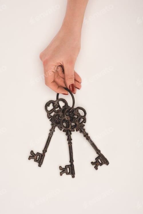 Preview: cropped image of female hand holding vintage keys isolated on white