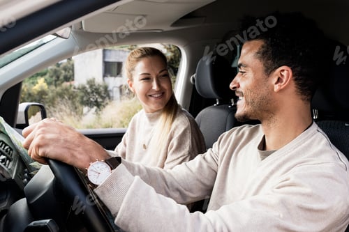 Preview: Young couple on a road trip. Man diving car with woman sitting on passenger seat.