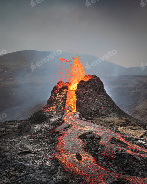 Preview: Beautiful shot of an active volcano with flowing lava and smoke under a clear sky