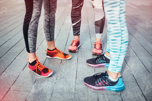 Preview: Legs of three female runners standing on wooden pier