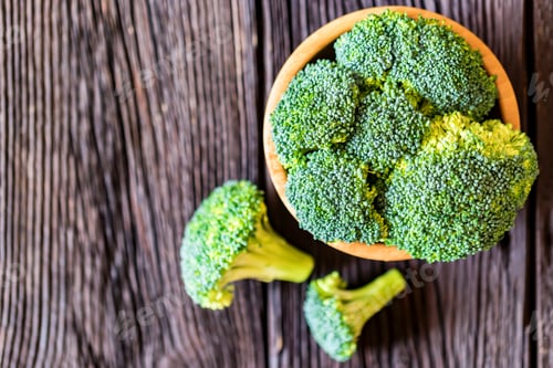 Preview: Fresh broccoli in wooden bowl on wooden surface