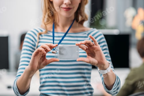 Preview: cropped image of young girl showing name tag at modern office