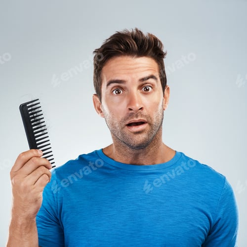 Worried Man Holding Comb with Hair Loss