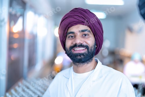 Preview: Beverage worker in drink factory stand smiling portrait with drink bottle and production line