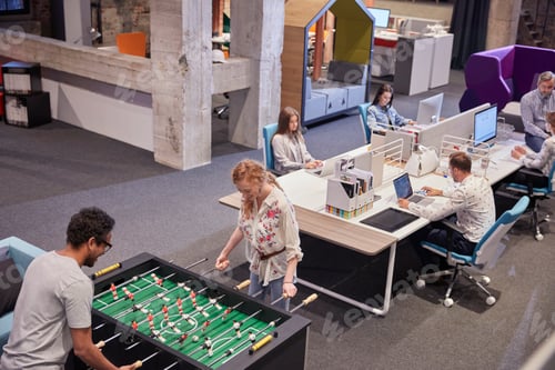 Preview: Business people in office taking a break, playing foosball