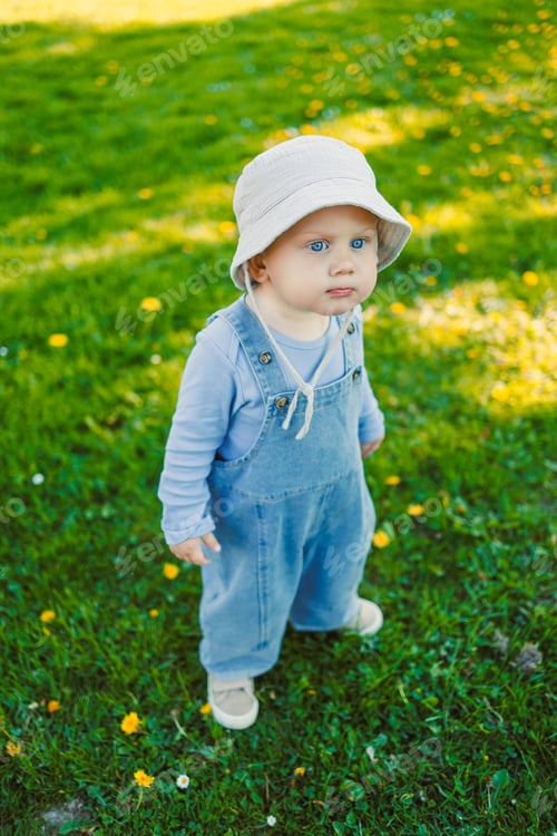 Preview: Cute boy running on the grass in a stylish shirt and sunbathing in the sun. Carefree childhood with