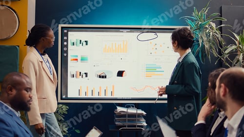 Preview: Marketing and PR team meeting to analyze infographics in conference room