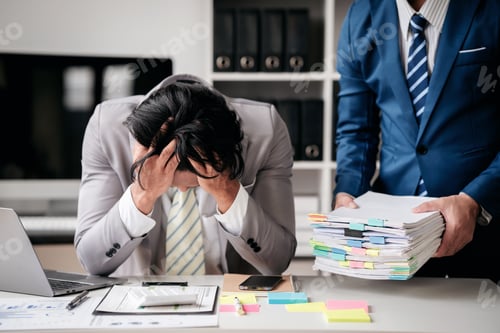 Preview: A man is sitting at a desk with a stack of papers in front of him