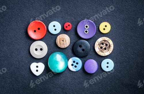 Preview: Sewing buttons lying on dark cloth