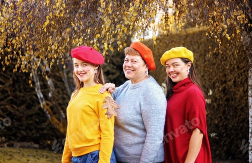 Preview: Mother, daughter and grandmother in bright colorful berets posing for photo having fun outdoors