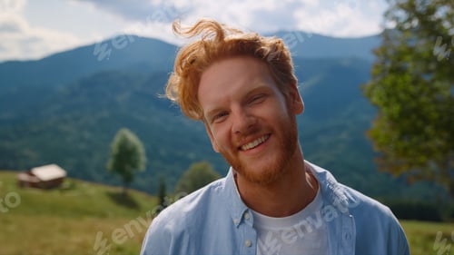 Preview: Closeup redhair man enjoying summer holiday in mountains. Portrait of happy guy.