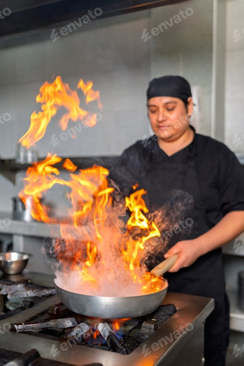 Preview: Peruvian chef cooking fish with flames in a restaurant kitchen