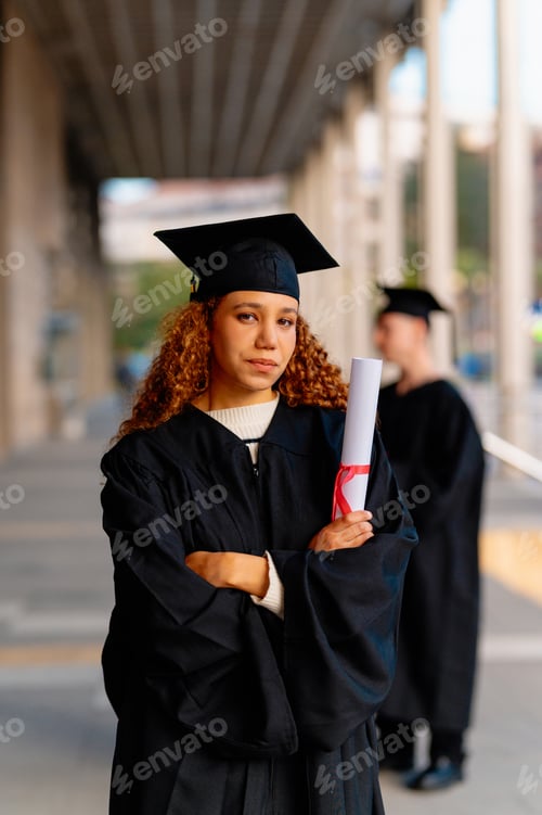 Preview: Proud graduate holding diploma on graduation day