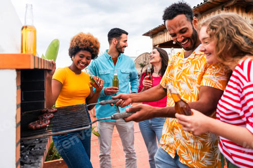 Preview: Multiethnic group of friends having dinner barbecue party on rooftop at home