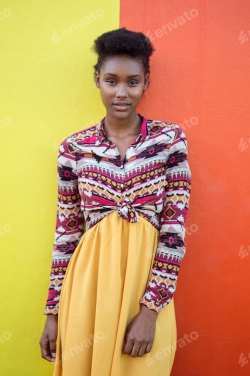 Preview: Young beautiful woman standing in front of red and yellow colorful background