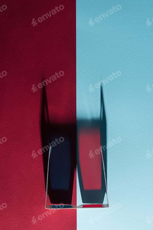 Preview: top view of cardboard 3d glasses with long vertical shadow on blue and bordo background