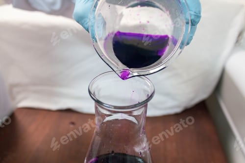 Preview: Person with blue gloves doing experiments with test tubes and purple liquid