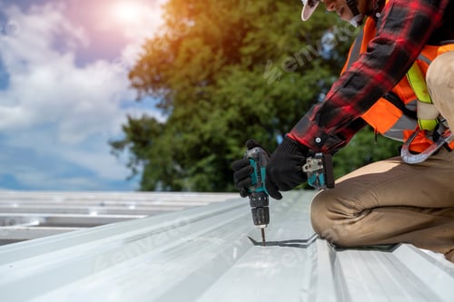 Preview: Worker with roofer tools wearing protective gear installing new roof on top roof.