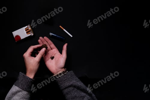Preview: Aerial view of unrecognizable male hand rolling a hash marihuana joint