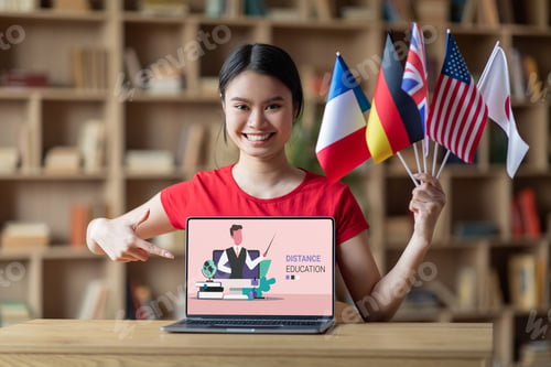 Preview: Happy asian lady student with international flags pointing at laptop