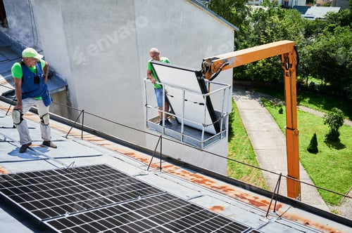 Preview: Workers building solar panel system on roof of house. Installers carrying photovoltaic solar module