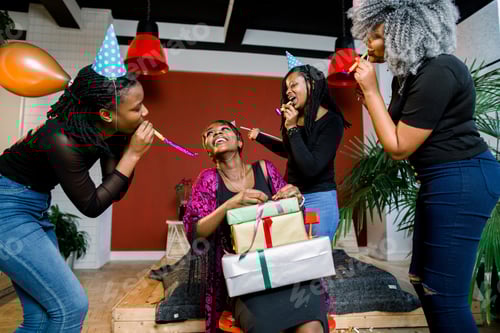 Preview: A beautiful smiling African girl opens a present at her birthday party