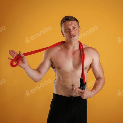 Preview: Red jump ropes, endurance and sport concept. Man is against background in the studio