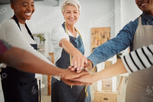Preview: Group of diverse clothing designers stacking their hands together in a shop at work. Tailors having