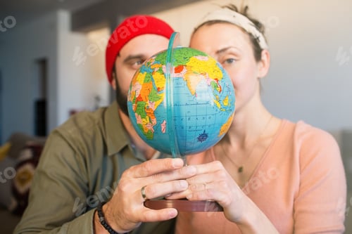 Preview: Happy young man and woman with globe choosing place for summer rest at leisure. Family travel.