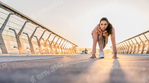 Preview: Sporty girl preparing for jogging on the bridge early in the morning