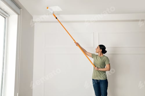 Preview: Young woman painting ceiling with white dye indoors, space for text