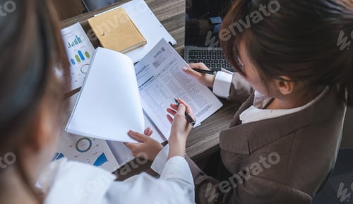 Preview: Business People Meeting using laptop computer,calculator,notebook,stock market chart paper for