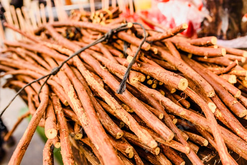 Preview: Stacks of dried licorice branches for sale.
