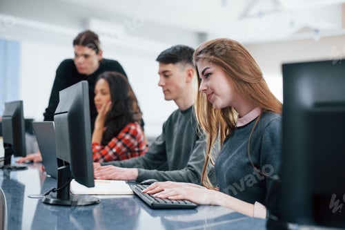 Preview: Computer screens. Group of young people in casual clothes working in the modern office