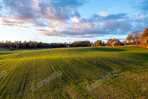 Preview: Picturesque autumn scene of a rolling hills of agricultural area from a birds eye view at sunset
