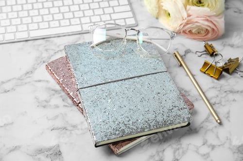 Preview: Blogger's workplace with notebooks and keyboard on marble table