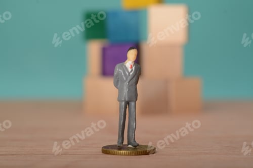 Preview: Miniature Figure on Coin near Building Blocks
