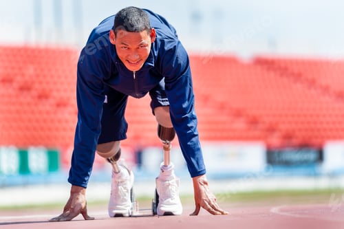 Preview: Front view of sport man athlete with a prosthesis on his leg action of start to run on the track