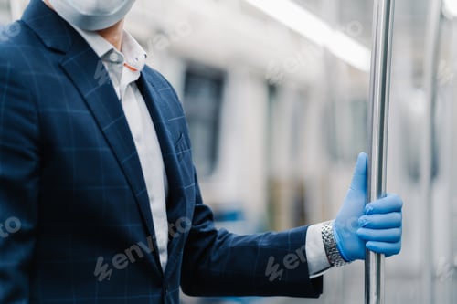 Preview: Man passenger wears protective medical glove from coronavirus, touches handrail in subway carriage